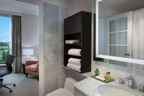 uma casa de banho com um lavatório e um espelho em Hilton Suites Toronto-Markham Conference Centre & Spa em Markham