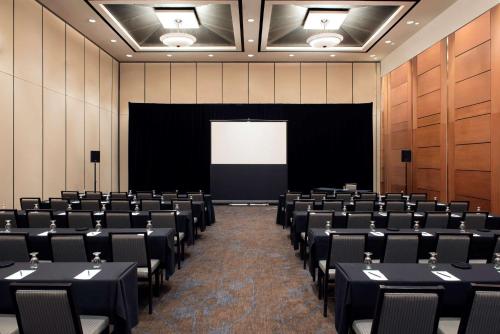 a conference room with tables and chairs and a screen at Hilton Suites Toronto-Markham Conference Centre & Spa in Markham