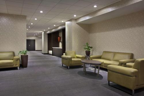 a waiting room with yellow couches and a table at Hilton Suites Toronto-Markham Conference Centre & Spa in Markham