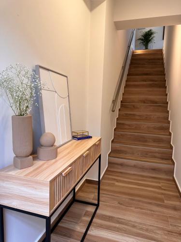 a staircase with wooden floors and a table with a vase on it at Casa Mare e Olio by All About Paxos in Gaios