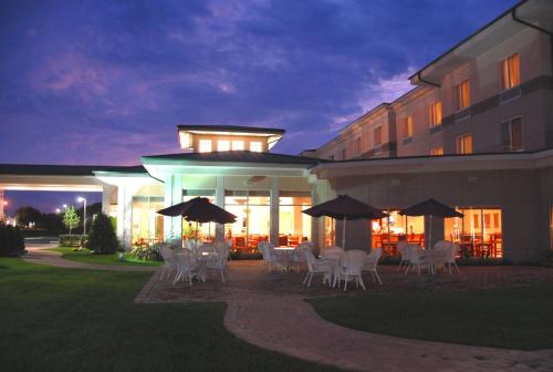 a patio with chairs and umbrellas in front of a building at Hilton Garden Inn Riverhead in Riverhead