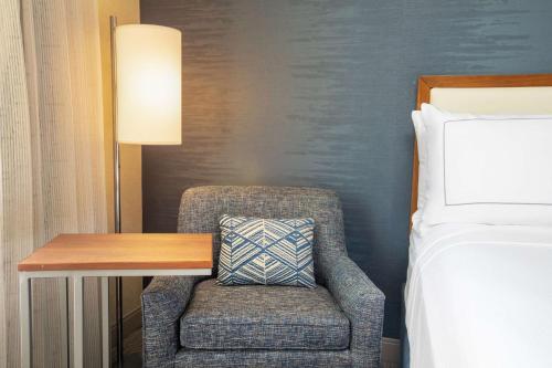 a bedroom with a chair and a desk next to a bed at DoubleTree by Hilton Ann Arbor, MI in Ann Arbor