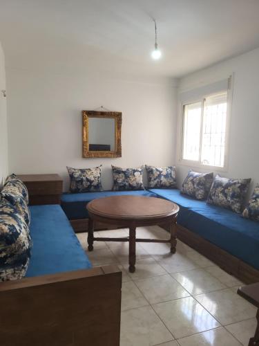 a living room with a blue couch and a table at Complexe tamuda doha tetouan in Tétouan