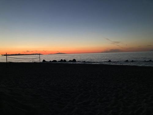 a sunset on a beach with the ocean at Villa Anna - Bifamiliare sul mare in Torregrotta