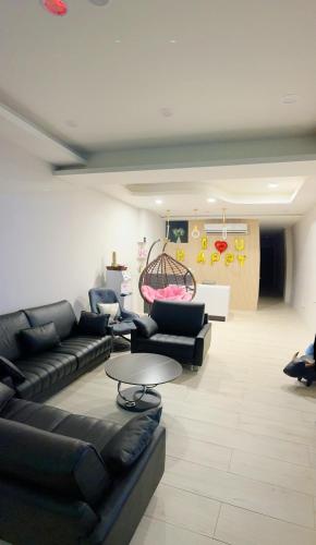 a living room with black leather couches and a table at 墾丁南灣包棟 光宿宅旅少人也可包棟 in Nanwan