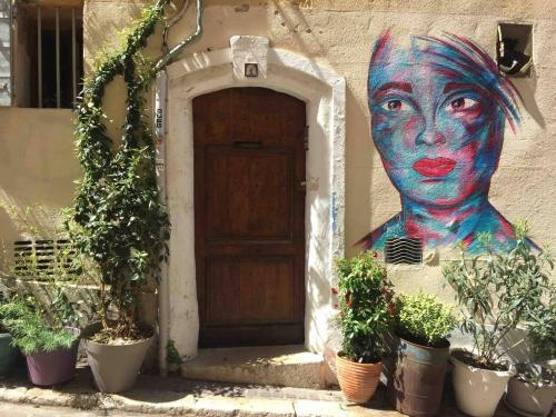 uma pintura de uma mulher ao lado de um edifício em Chez Serge em Marselha