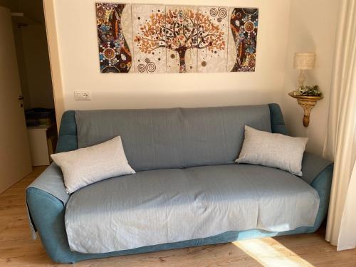 a blue couch with two pillows in a living room at Maison Eglantine in Mezzana