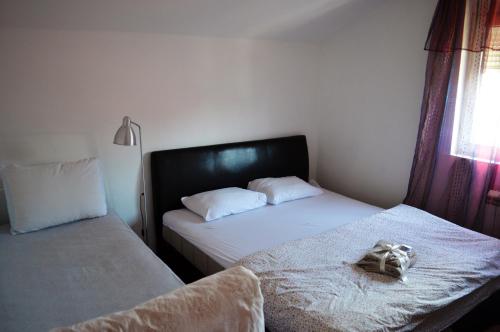 een slaapkamer met 2 bedden en een badjas op het bed bij House of peace in Podgorica