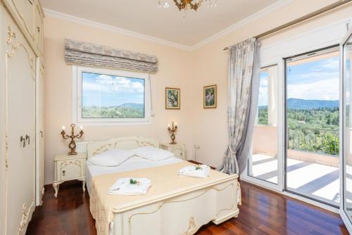 a bedroom with a bed and a large window at Villa Denise in Pouládes