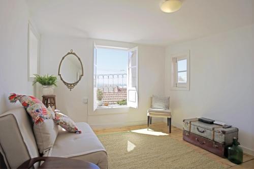 uma sala de estar com um sofá e um espelho em Stay local in Alfama! Deolinda central Home, amazing view em Lisboa