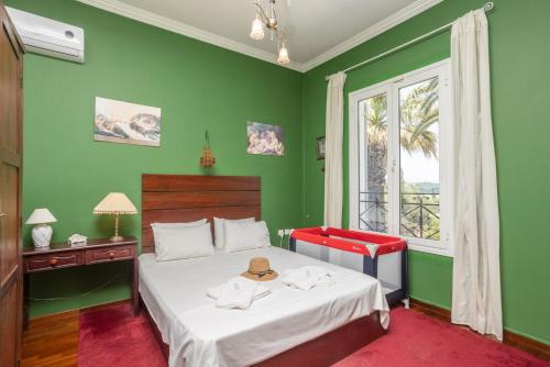 zieloną sypialnię z łóżkiem i oknem w obiekcie Villa Golden Tiara w Korfu