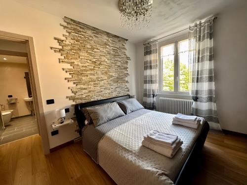 a bedroom with a brick wall and a bed at Residenza Basilica in Tirano