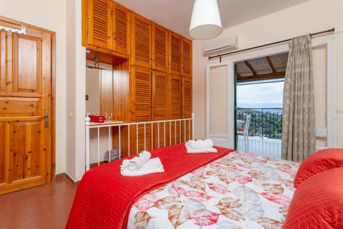 a bedroom with a bed with a red blanket and a window at Bougainvillea in Gimari