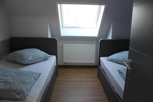 two beds in a small room with a window at Auszeit im 8erland in Rankwitz