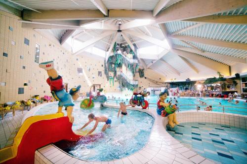 a indoor water park with people playing in a pool at Oostappen Vakantiepark Prinsenmeer BV in Asten