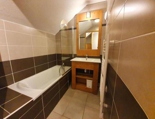 une salle de bain avec une baignoire, un lavabo et un miroir dans l'établissement Confortable duplex au pied des pistes, 3 pièces, 6 couchages, 2 SdB, balcon Sud, à Vars