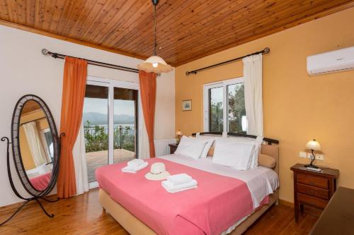 a bedroom with a bed with a mirror and a window at Villa Eleni in Agnítsini