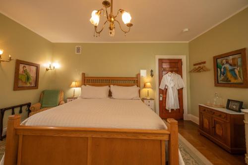 a bedroom with a large bed and a chandelier at Cartier Mansion in Ludington
