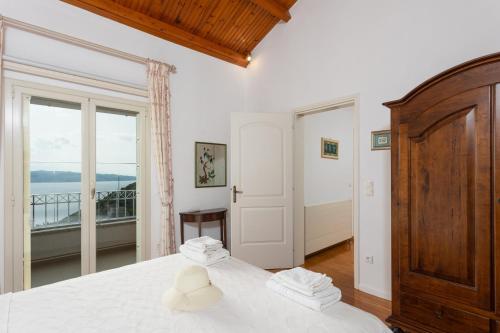 a bedroom with a bed and a balcony at Villa Anastasia in Agnítsini