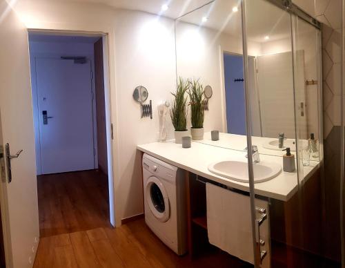 Apartament Rodzinny Sarbinowo في ساربينوفو: حمام مع مغسلة وغسالة ملابس