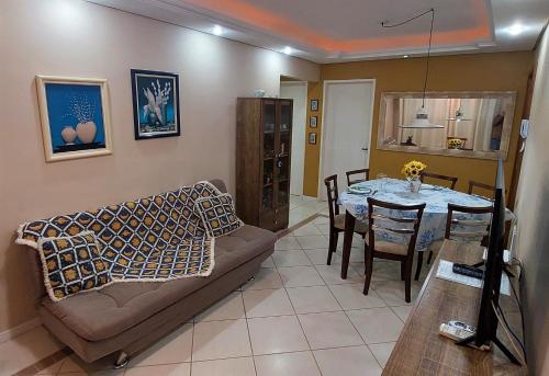 a living room with a couch and a table at Apartamento Completo 2 Quartos Wi-Fi 300 Mbps in Porto Alegre