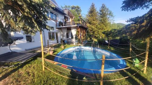 a house with a swimming pool in the yard at Panoráma Apartman Pilisszántó in Pilisszántó