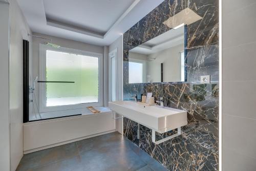 a bathroom with a sink and a mirror at VB Higueron 4BDR Villa w Pool, Cinema & Ping pong in Benalmádena