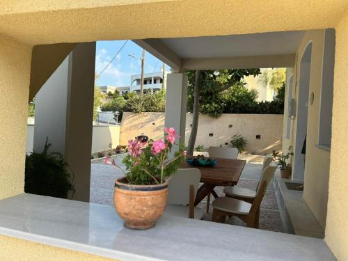 een vaas met roze bloemen op een balkon bij Blue Flag Award Winning Ormos Lo Beach: Home 1 in Vrontádos