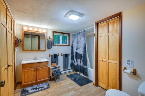 a bathroom with a sink and a wooden door at Brantingham Cottage with Fire Pit and Forested Views! in Glenfield