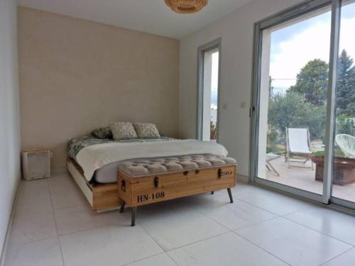 a bedroom with a bed and a large window at Villa de charme à Saint-Chamas au bord de l'étang. in Saint-Chamas