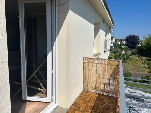 einen Balkon mit einer Glasschiebetür und Aussicht in der Unterkunft Au coeur des Chênes, 2p in Ploemeur