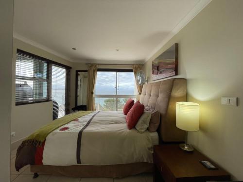 sypialnia z dużym łóżkiem i oknem w obiekcie Nautica Flat 301 w mieście Mossel Bay
