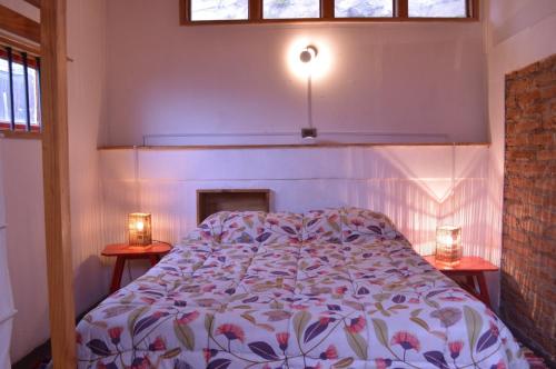 een slaapkamer met een bed en twee kaarsen op twee tafels bij Casa en Valparaíso con vista al mar in Valparaíso