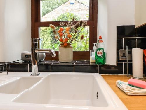 a white sink in a kitchen with a window at Willow Cottage in Clitheroe