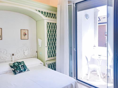 ベッラーリア・イジェア・マリーナにあるHotel Orizzonteのベッドルーム1室(ベッド1台付)、スライド式ガラスドアが備わります。