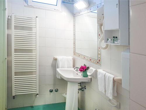 a white bathroom with a sink and a mirror at Hotel Orizzonte in Bellaria-Igea Marina