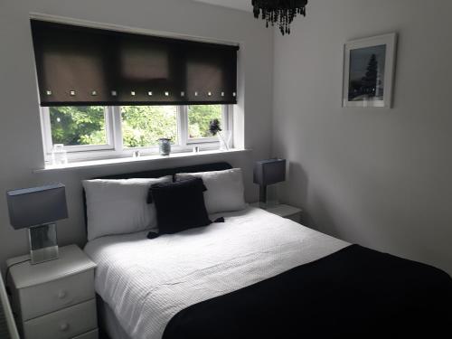 - une chambre avec un lit noir et blanc et 2 fenêtres dans l'établissement A&S properties, no guest fees, with drive and near city centre, à Wolverhampton