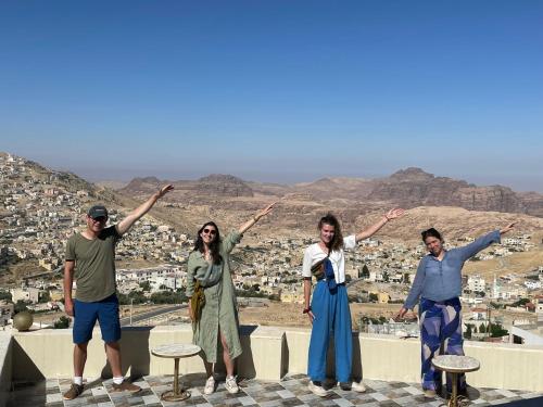 a group of people standing on a ledge with their arms up at Cozy House in Wadi Musa