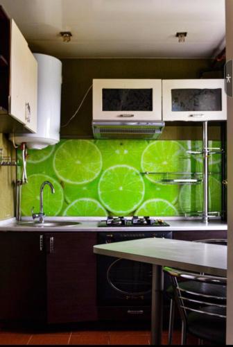 - une cuisine avec un mur vert, un évier et une cuisinière dans l'établissement Апартаменты в стиле Loft, à Nizhnedneprovsk