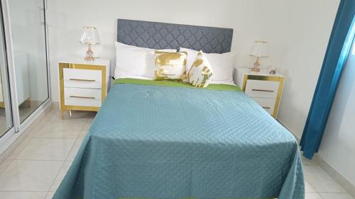 1 dormitorio con 1 cama azul y 2 mesitas de noche en RG Sol 1, en Pantoja