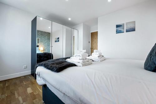 a bedroom with a large white bed with towels on it at Stunning Flat on King's Road, Chelsea with Balcony in London