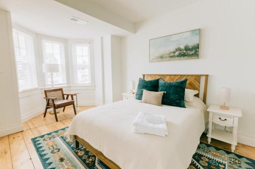 a white bedroom with a bed and a chair at Newly Renovated Vintage Inspired Large 4 BR Home in Mount Joy