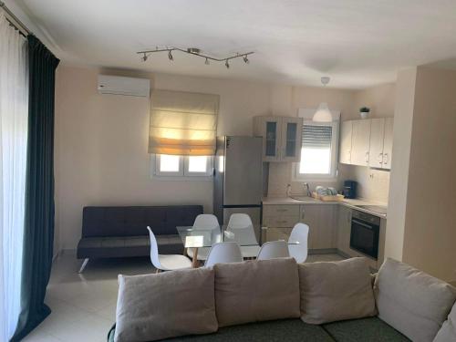 a living room with a couch and a table and chairs at Elia Luxury Maisonettes in Siviri