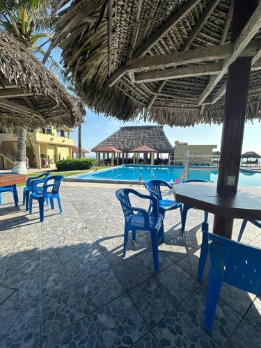 a patio with tables and chairs and a swimming pool at Canadian Resort Veracruz in Costa Esmeralda