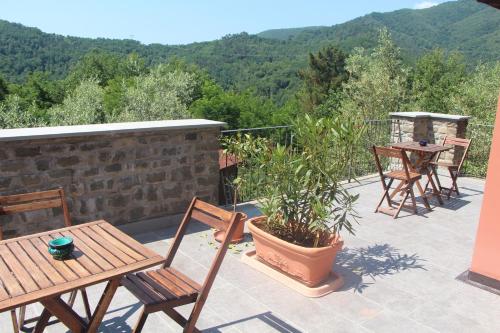 un patio con mesa, sillas y montañas en Il Cargedo, en Mulazzo