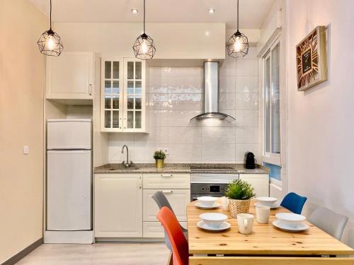 a kitchen with a wooden table with chairs and appliances at Charming Puerta del Sol Center - 6 Bedrooms in Madrid