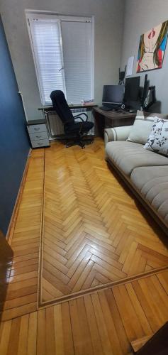 a living room with a couch and a wooden floor at Уютная трехкомнатная квартира с видом на море в Баку in Baku