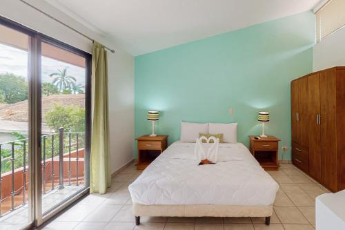 1 Schlafzimmer mit einem Bett mit 2 Lampen und einem Balkon in der Unterkunft Flamenco Rosa A13 in Coco
