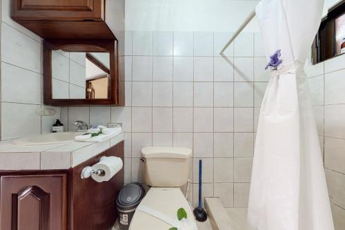 ein Badezimmer mit einem WC, einem Waschbecken und einem Spiegel in der Unterkunft Flamenco Rosa A13 in Coco