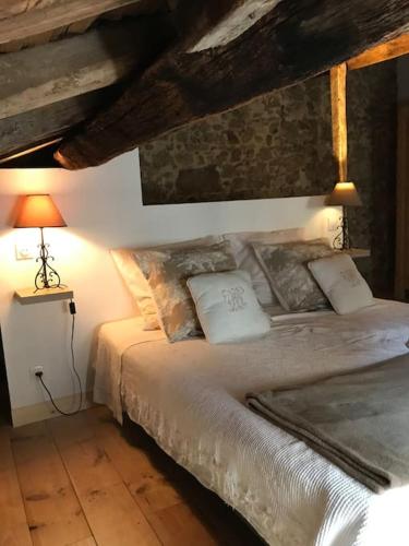 une chambre avec un lit avec deux oreillers dessus dans l'établissement Petite Maison médiévale, à Parthenay